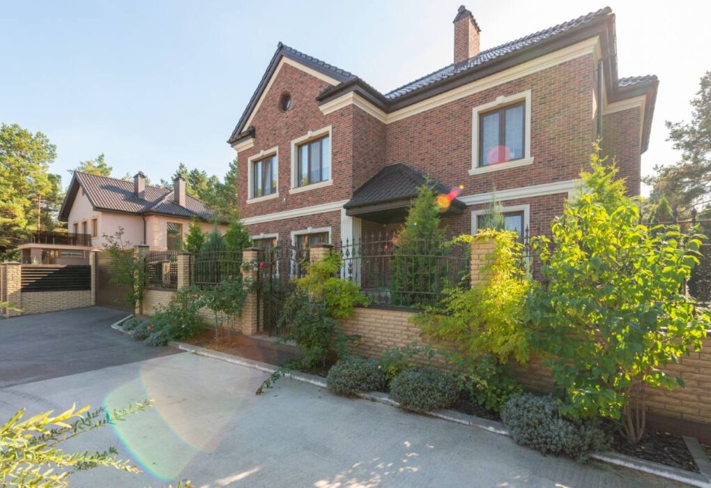 Brick vs siding: two-story brick house exterior with a landscaped garden and driveway