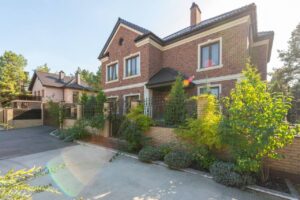Brick vs siding: two-story brick house exterior with a landscaped garden and driveway