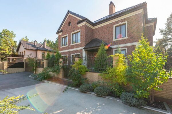 Brick vs siding: two-story brick house exterior with a landscaped garden and driveway